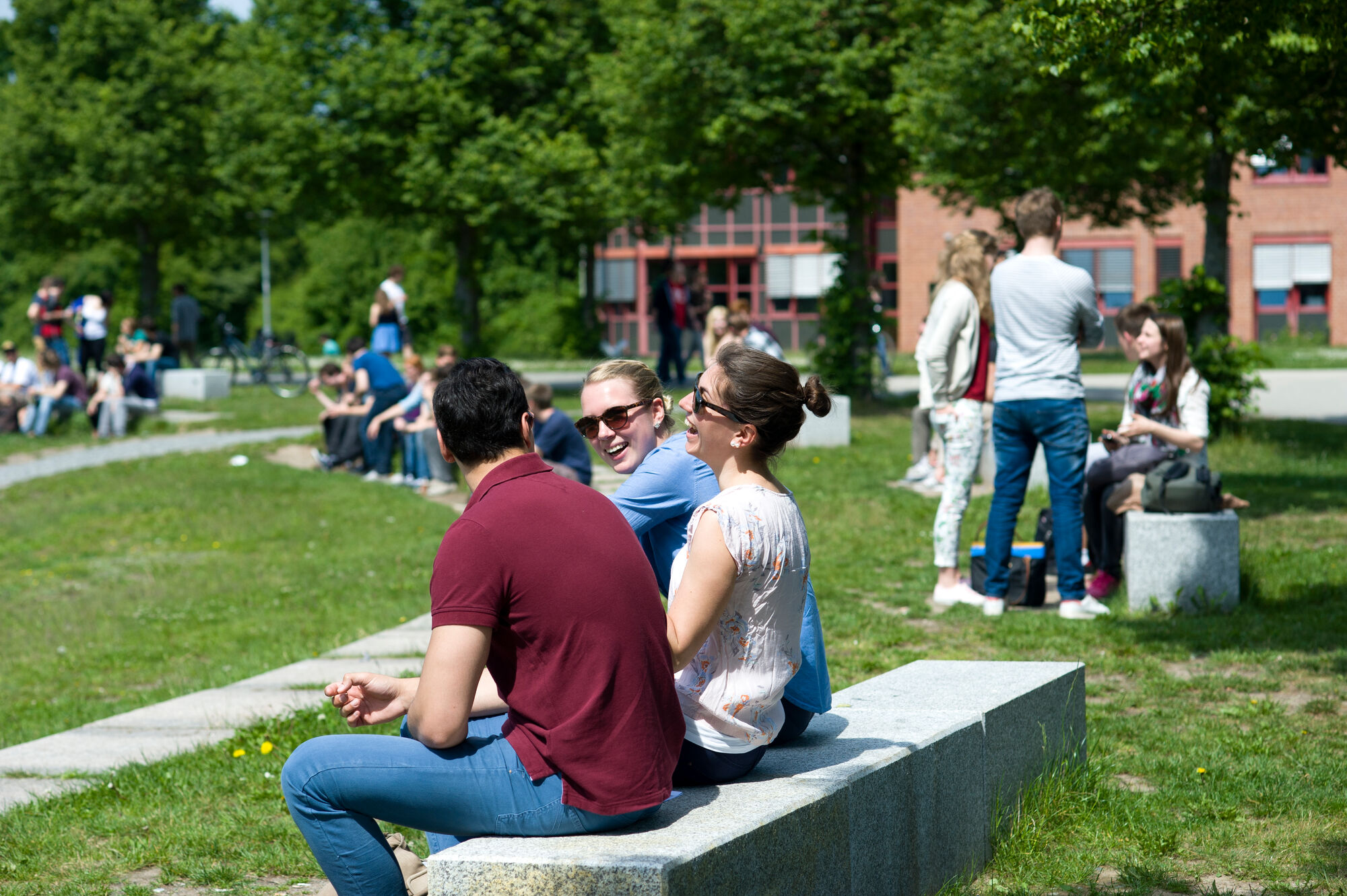 Hier sehen Sie mehrere Studierende beim Rondell der Uni.